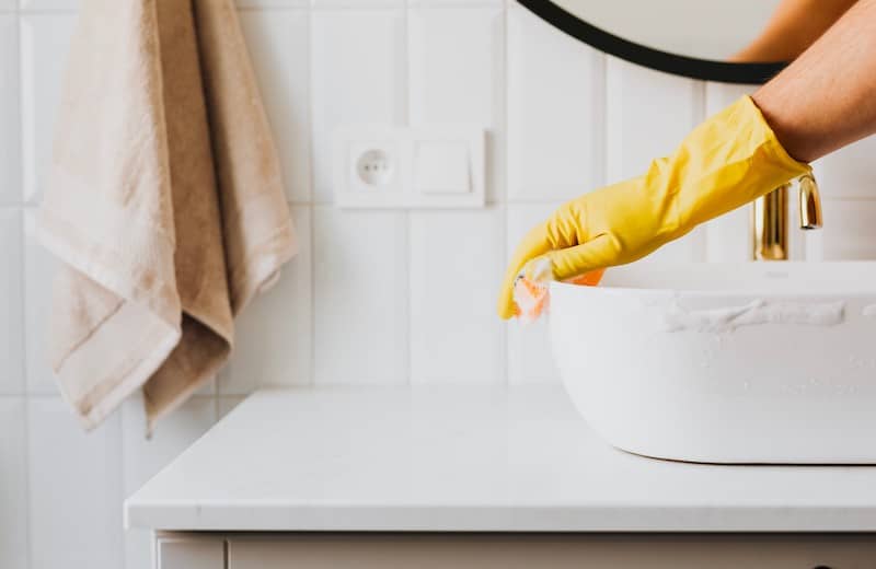 Une femme de ménage qui nettoie une salle de bain