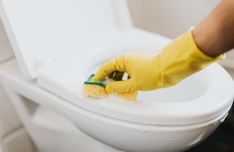 Une femme de ménage qui nettoie des toilettes